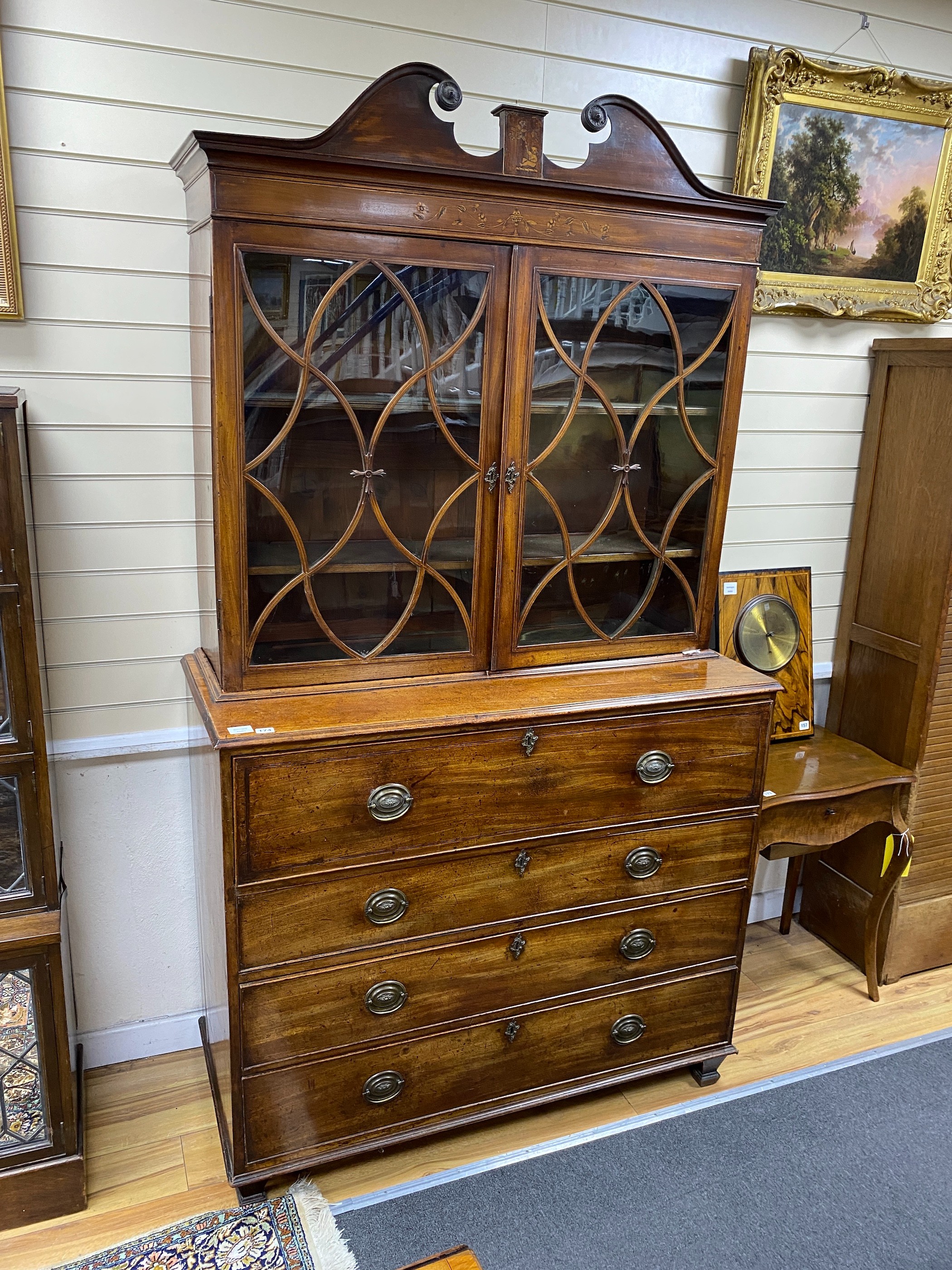 A Regency mahogany secretaire bookcase, fitted over with an earlier two door glazed cabinet, width 121cm, depth 52cm, height 214cm